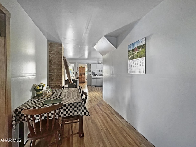 dining space with light wood-type flooring and lofted ceiling