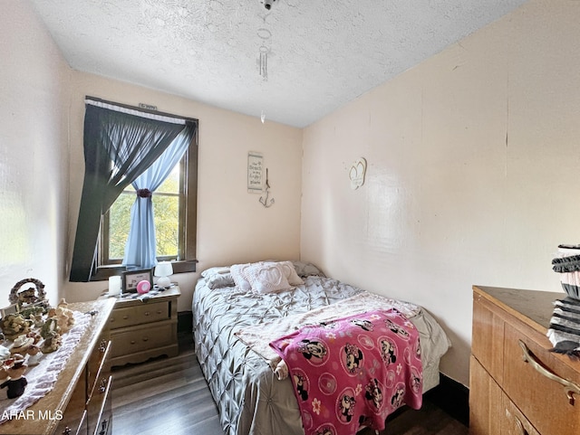 bedroom with dark wood-type flooring and a textured ceiling