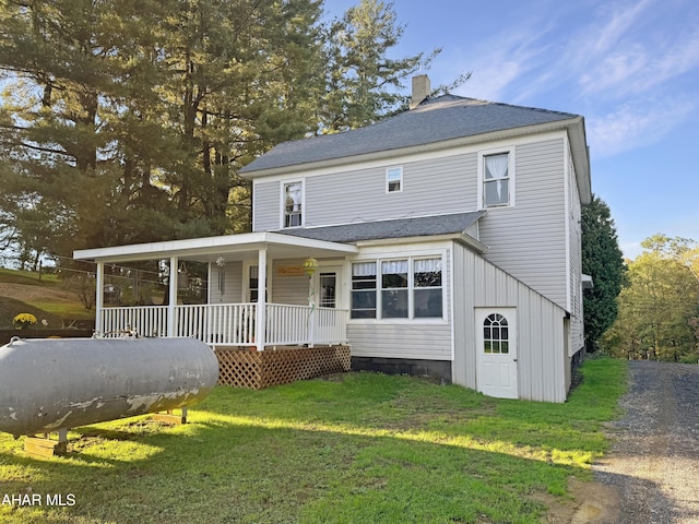 view of front of home with covered porch and a front lawn