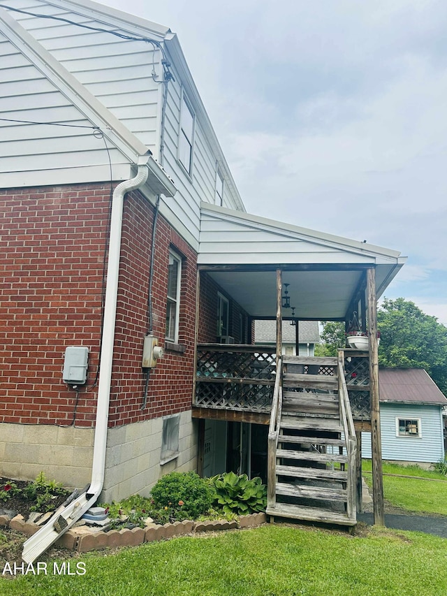 14 W 2nd St, Everett, PA 15537 - view of side of home with brick siding, stairs, a lawn, and a wooden deck
