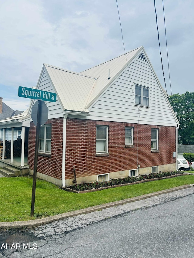 14 W 2nd St, Everett, PA 15537 - view of side of home with brick siding, a yard, and a metal roof