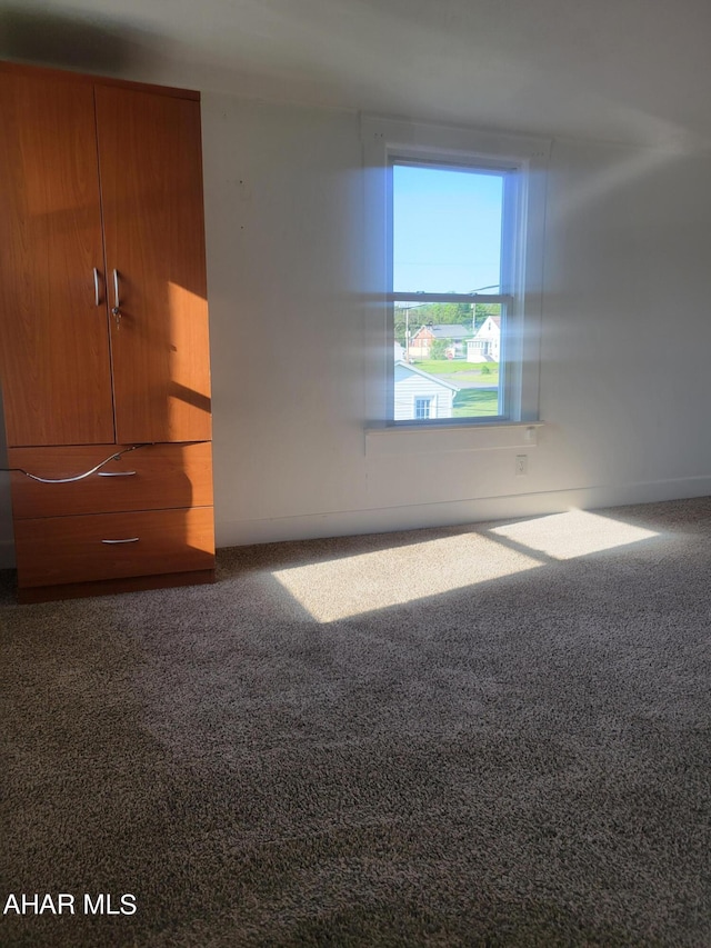 unfurnished bedroom featuring dark colored carpet