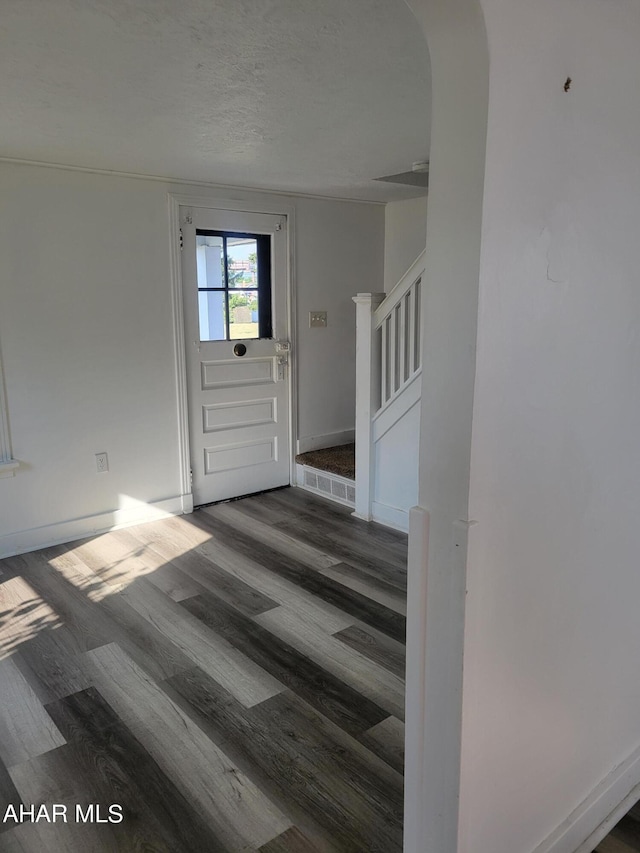 entrance foyer featuring dark wood-type flooring and a textured ceiling