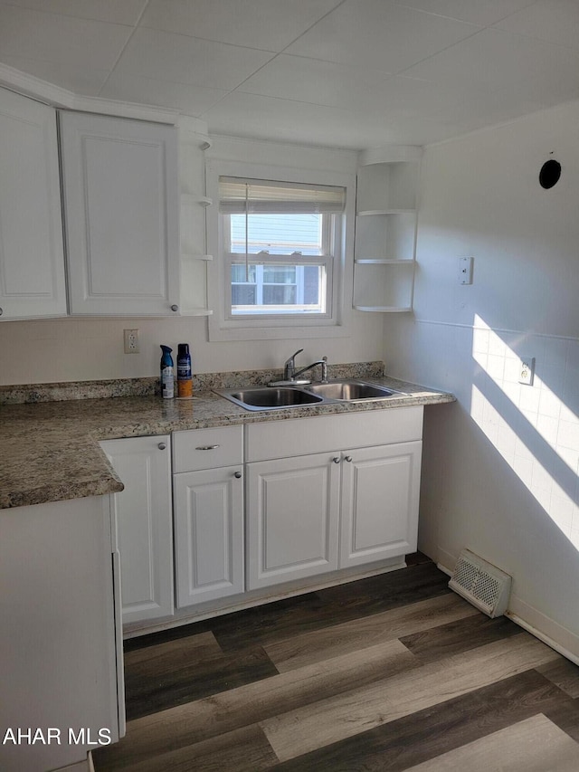 kitchen featuring dark hardwood / wood-style floors, white cabinetry, and sink