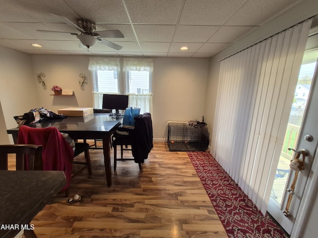 dining space featuring ceiling fan, wood finished floors, and a paneled ceiling