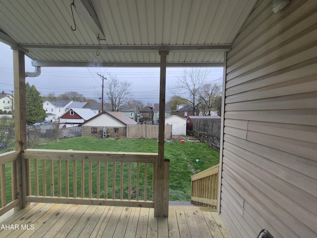 deck with a fenced backyard, a yard, a residential view, a shed, and an outdoor structure