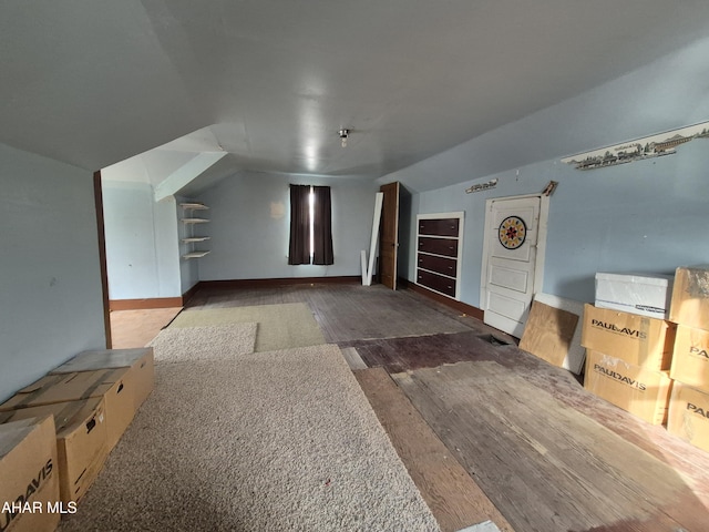 additional living space with vaulted ceiling and wood finished floors