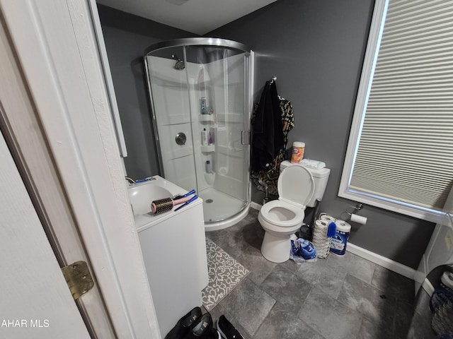 full bath featuring toilet, baseboards, vanity, and a stall shower