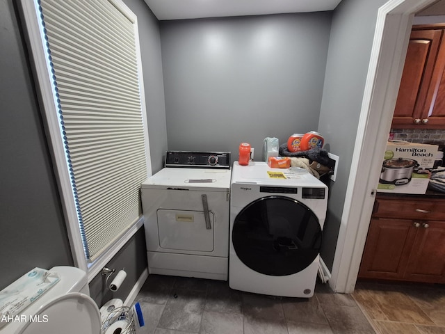 washroom with washing machine and clothes dryer, baseboards, and laundry area