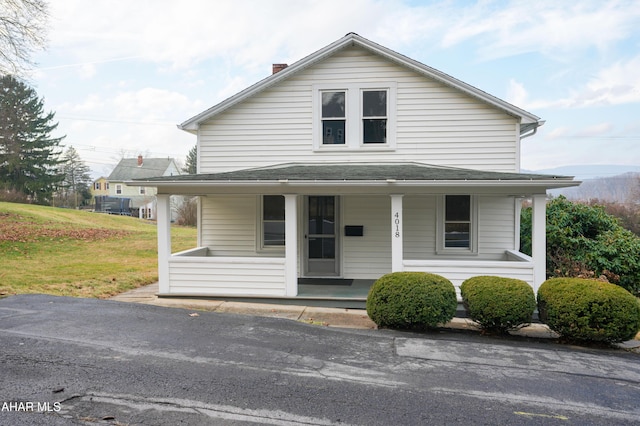 farmhouse inspired home with covered porch and a front lawn