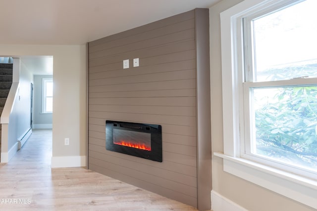 details with a baseboard radiator, hardwood / wood-style floors, and a fireplace