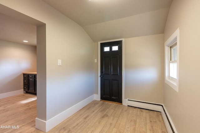 entryway with lofted ceiling, light wood-type flooring, and baseboard heating