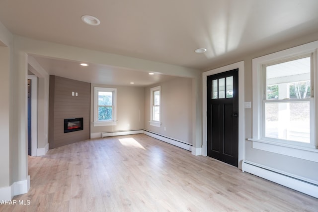 foyer featuring light hardwood / wood-style flooring, a fireplace, and a baseboard radiator