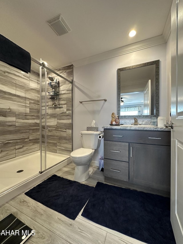 full bathroom featuring visible vents, crown molding, a stall shower, vanity, and toilet