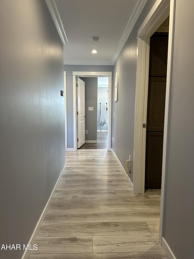 hallway with crown molding, baseboards, recessed lighting, and light wood-type flooring