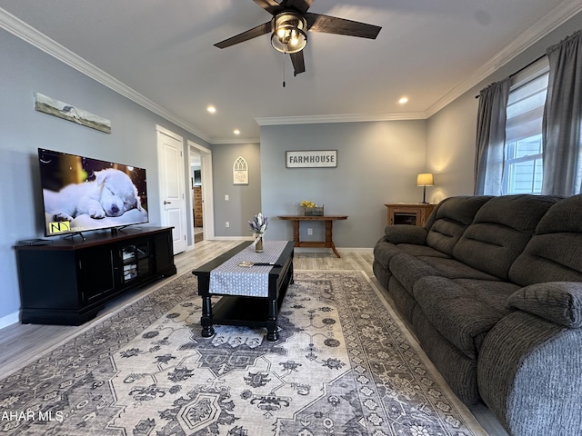 living area with baseboards, ceiling fan, ornamental molding, and wood finished floors