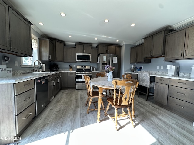 kitchen with crown molding, a sink, recessed lighting, and stainless steel appliances