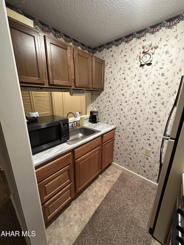 laundry room featuring sink and a textured ceiling