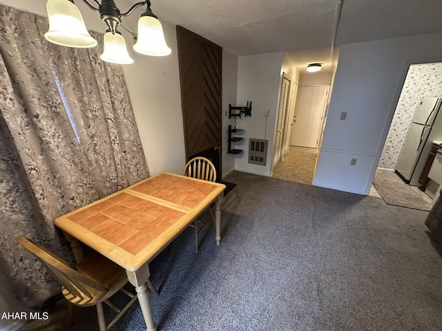 carpeted dining area with heating unit and a textured ceiling