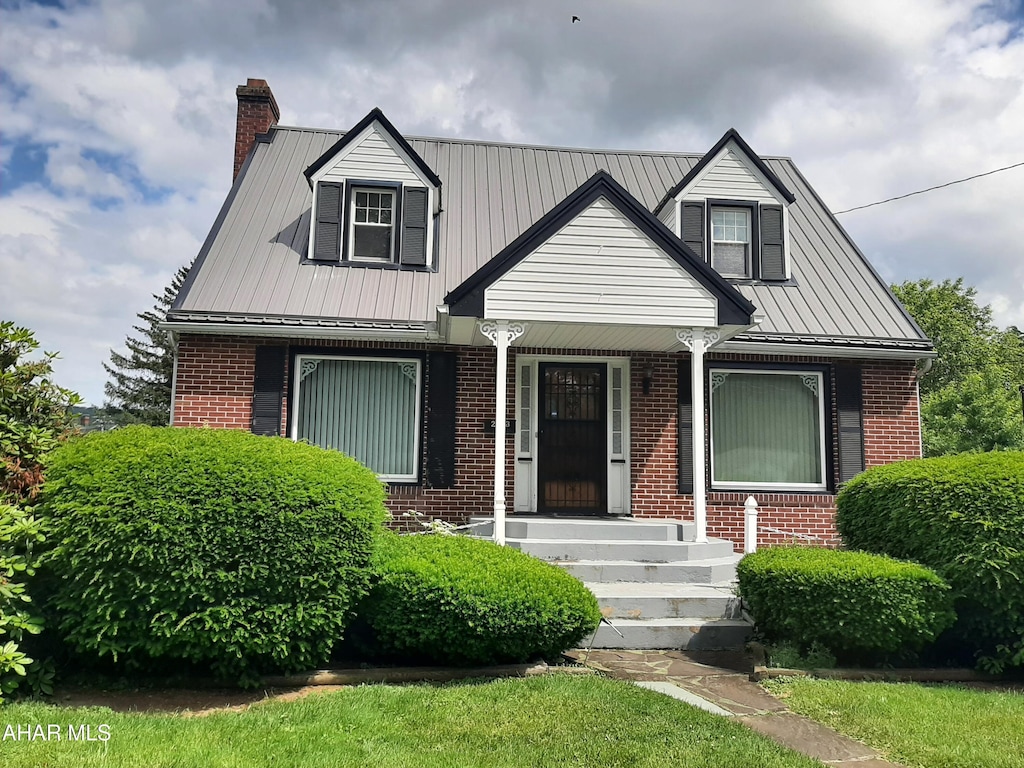 213 Milton Ave, Altoona, PA 16602 - view of front facade with brick siding, covered porch, a chimney, a metal roof, and a standing seam roof