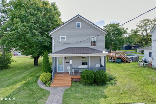 rear view of house with a lawn and a porch