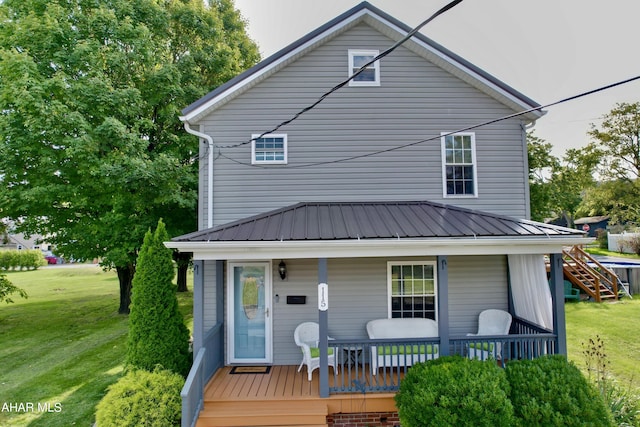 back of property featuring covered porch and a lawn