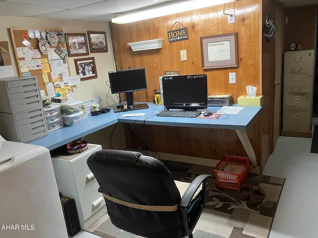 home office featuring a paneled ceiling, wood walls, and washer / dryer