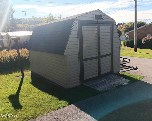 view of outbuilding featuring a lawn