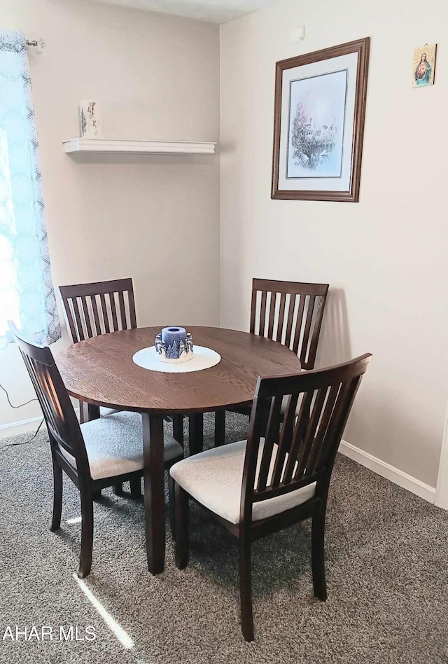 dining room featuring carpet flooring and baseboards