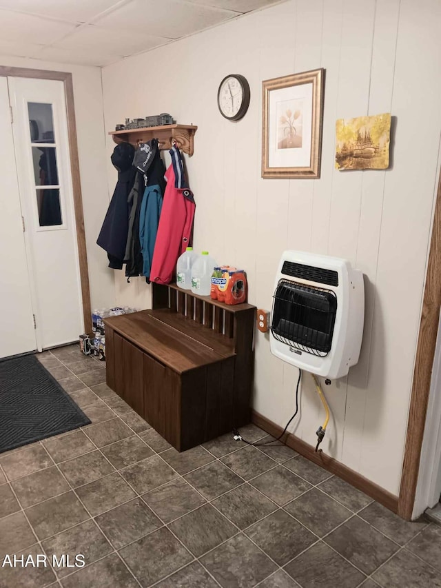 mudroom featuring heating unit and dark tile patterned flooring