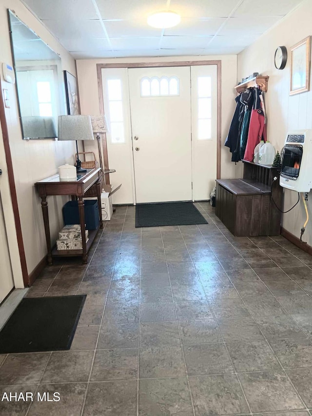 foyer featuring heating unit, a paneled ceiling, and baseboards