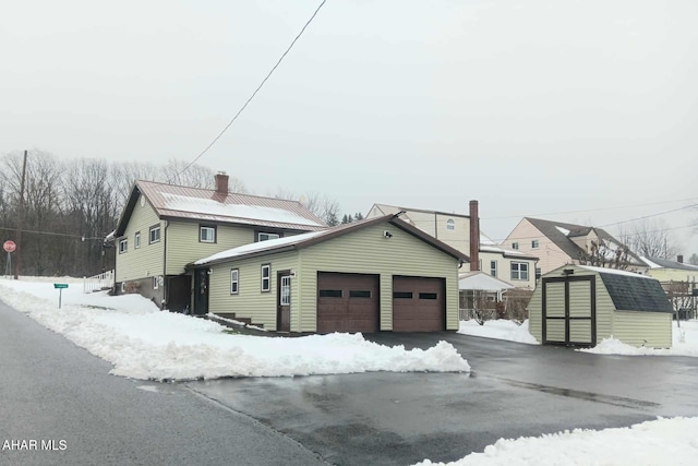 view of front of house with a garage and a storage unit