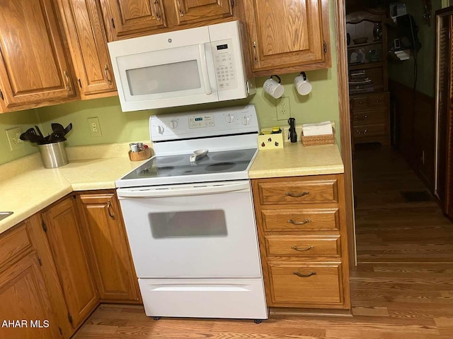 kitchen with wood-type flooring and white appliances