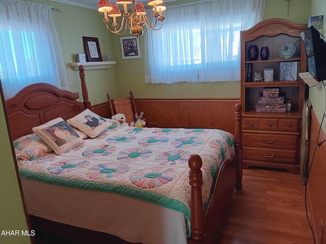 bedroom featuring a notable chandelier and wood finished floors