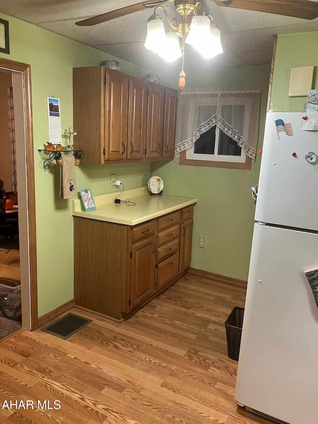 kitchen with ceiling fan, white refrigerator, and light hardwood / wood-style flooring