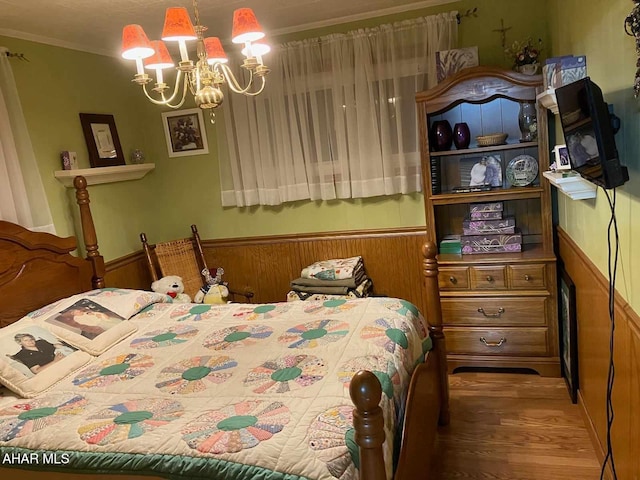 bedroom featuring wood walls, crown molding, a chandelier, and hardwood / wood-style flooring