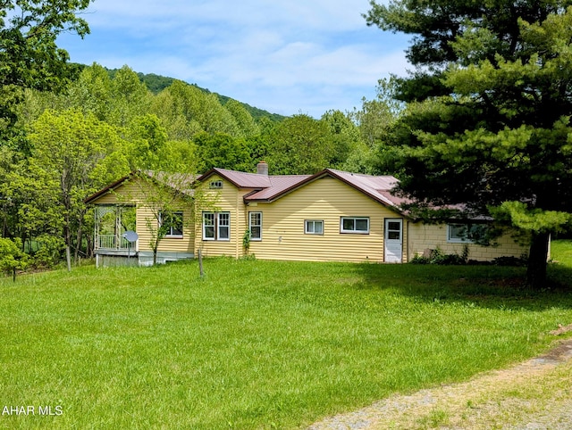 157 Cove Rd, Buffalo Mills, PA 15534 - back of property featuring a chimney, a yard, a metal roof, and a wooded view