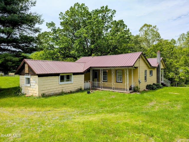 157 Cove Rd, Buffalo Mills, PA 15534 - view of front of home with covered porch, a front lawn, a chimney, and a metal roof