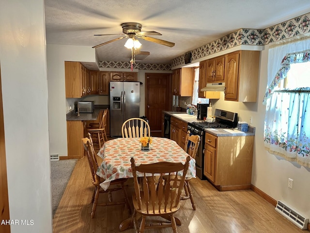 kitchen with black appliances, sink, light hardwood / wood-style flooring, ceiling fan, and a textured ceiling