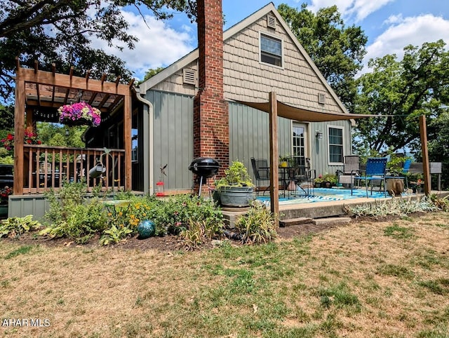 rear view of property with a pergola and a lawn