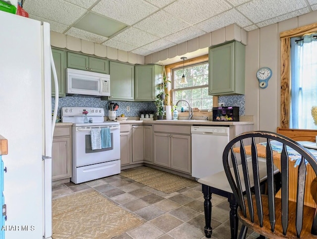 kitchen featuring backsplash, a paneled ceiling, white appliances, sink, and green cabinets