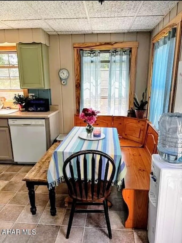 tiled dining area with plenty of natural light and a drop ceiling