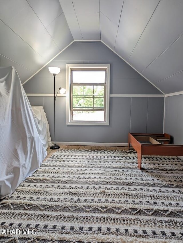 additional living space with carpet floors and vaulted ceiling