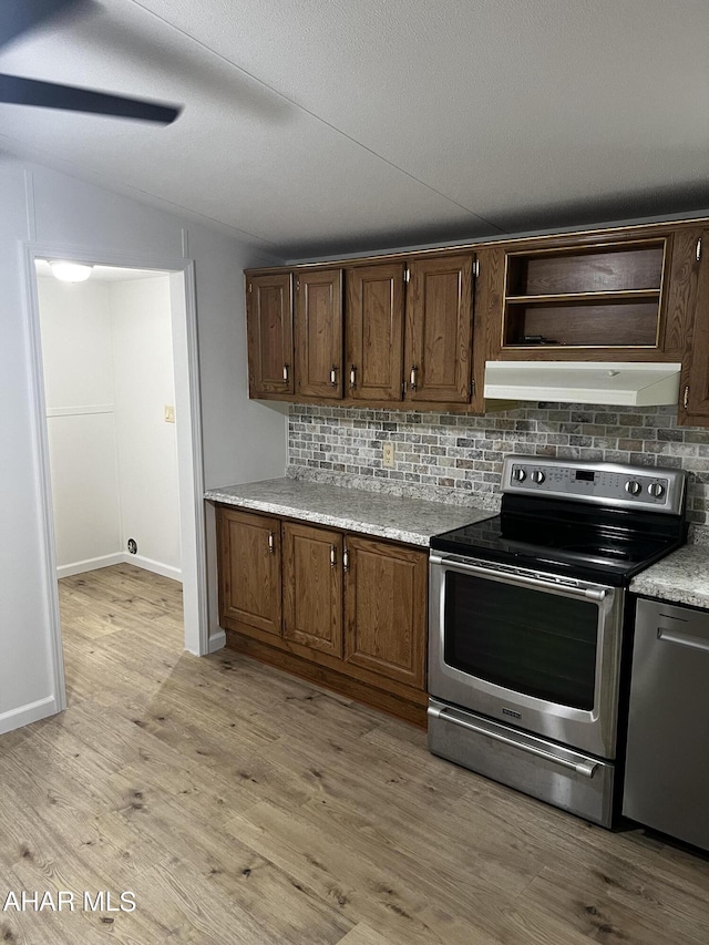 kitchen with backsplash, dark brown cabinets, stainless steel appliances, and light wood-type flooring