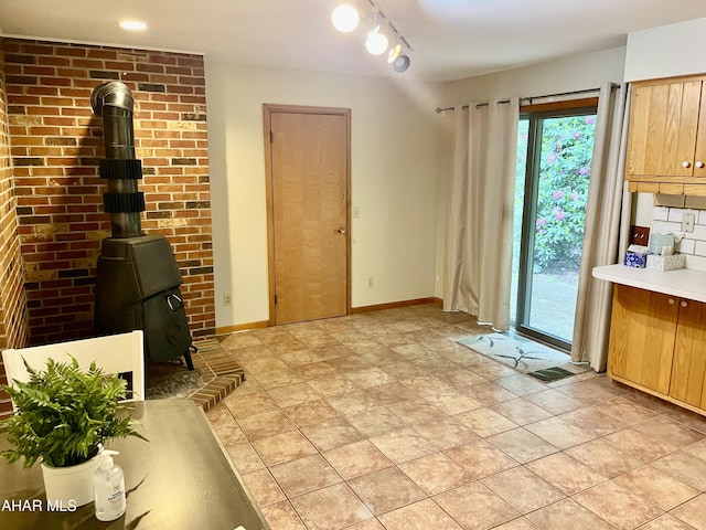 508 Oakwood Dr, Bedford, PA 15522 - unfurnished dining area featuring a wood stove, plenty of natural light, baseboards, and light stone finish flooring