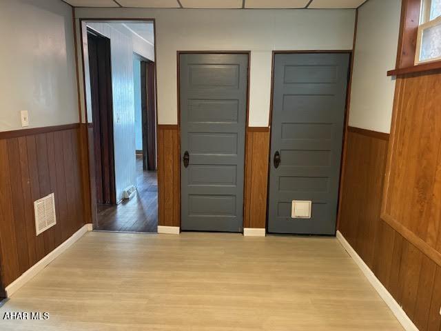 215 N 10th Ave, Altoona, PA 16601 - entryway featuring a wainscoted wall, light wood-type flooring, wood walls, and plenty of natural light