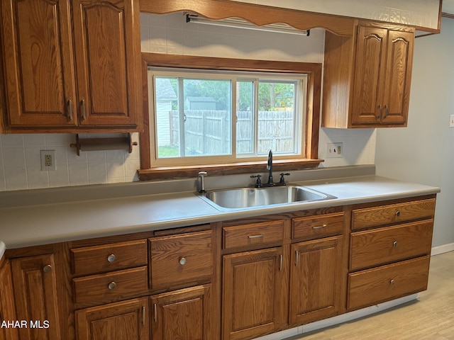 215 N 10th Ave, Altoona, PA 16601 - kitchen with brown cabinetry, backsplash, and light wood-style flooring