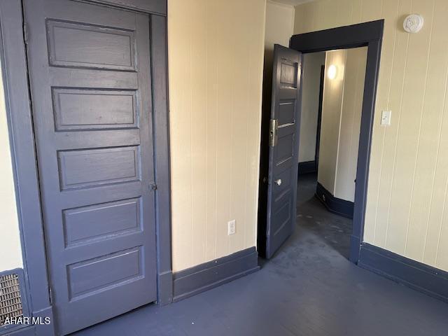 1008 21st Ave, Altoona, PA 16601 - unfurnished bedroom featuring concrete flooring and wooden walls