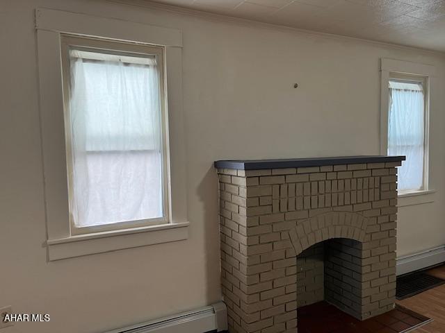 1008 21st Ave, Altoona, PA 16601 - detailed view of wood finished floors, a baseboard heating unit, and ornamental molding