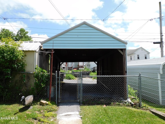 view of outdoor structure featuring fence, a gate, and a detached carport
